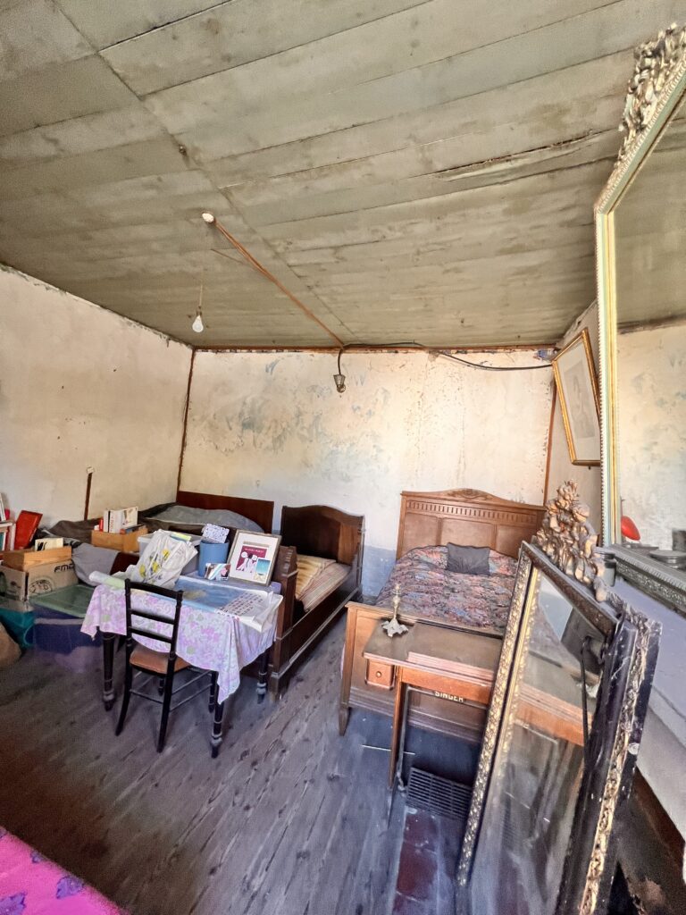 Pièce avant rénovation, plafond en lambris et murs abîmés