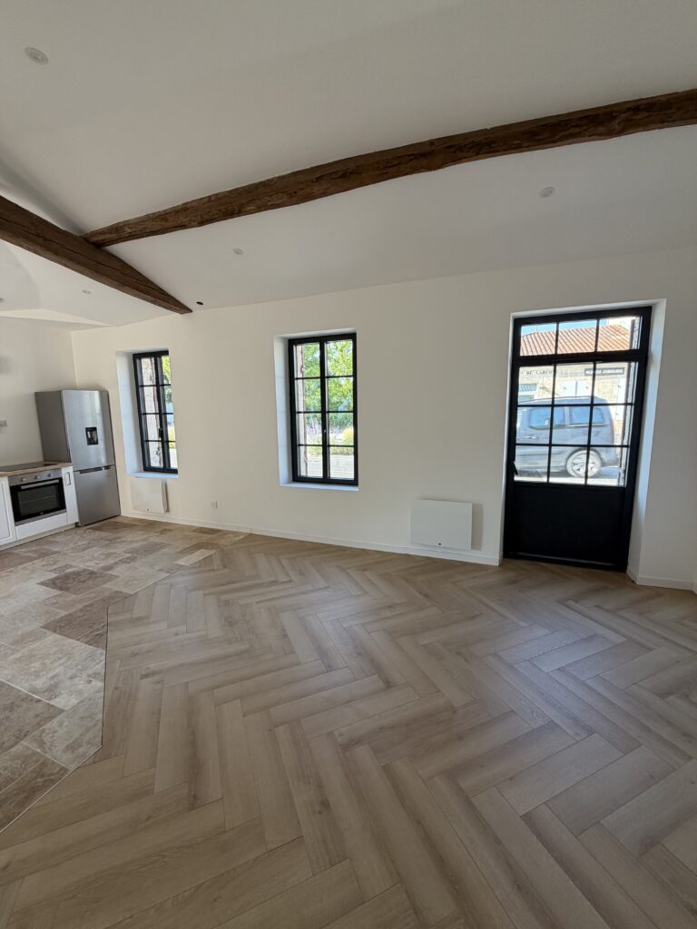 Séjour rénové avec menuiseries noires et parquet chevron